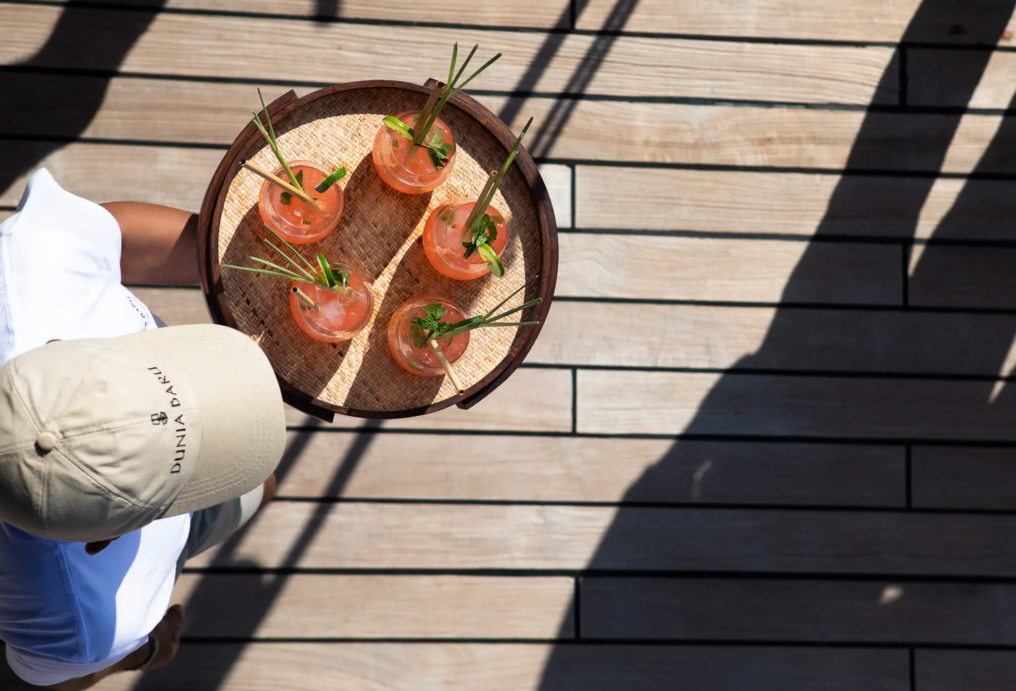 Canapés carried across Dunia Baru's teak deck on a woven tray by a crew member