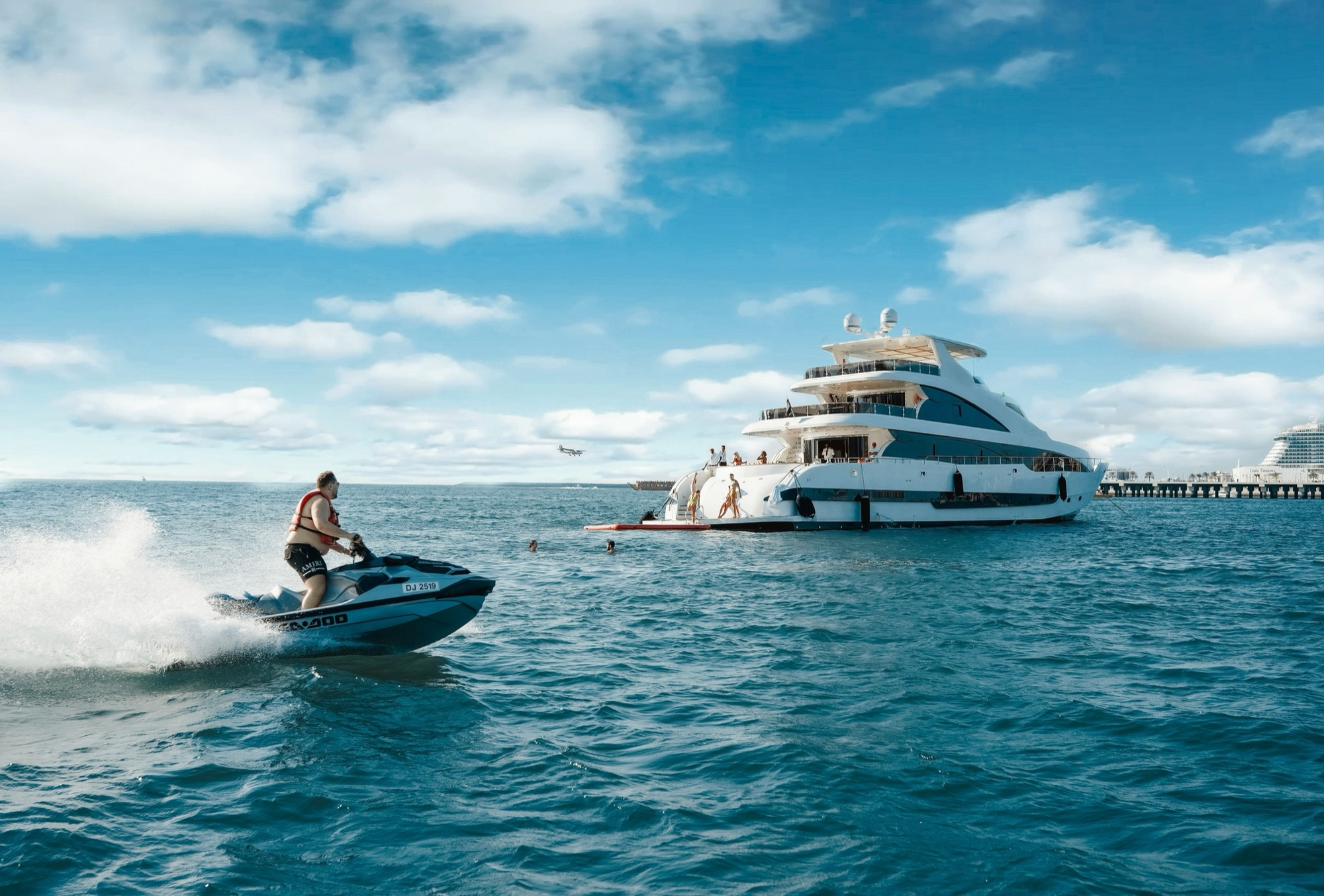 A guest on a jet ski beside a superyacht at anchor